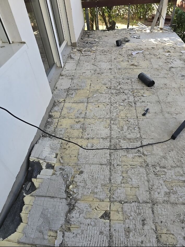 Dieselbe Dachterrasse vorher mit verwitterten Betonplatten, offenen Fugen und Bauschutt