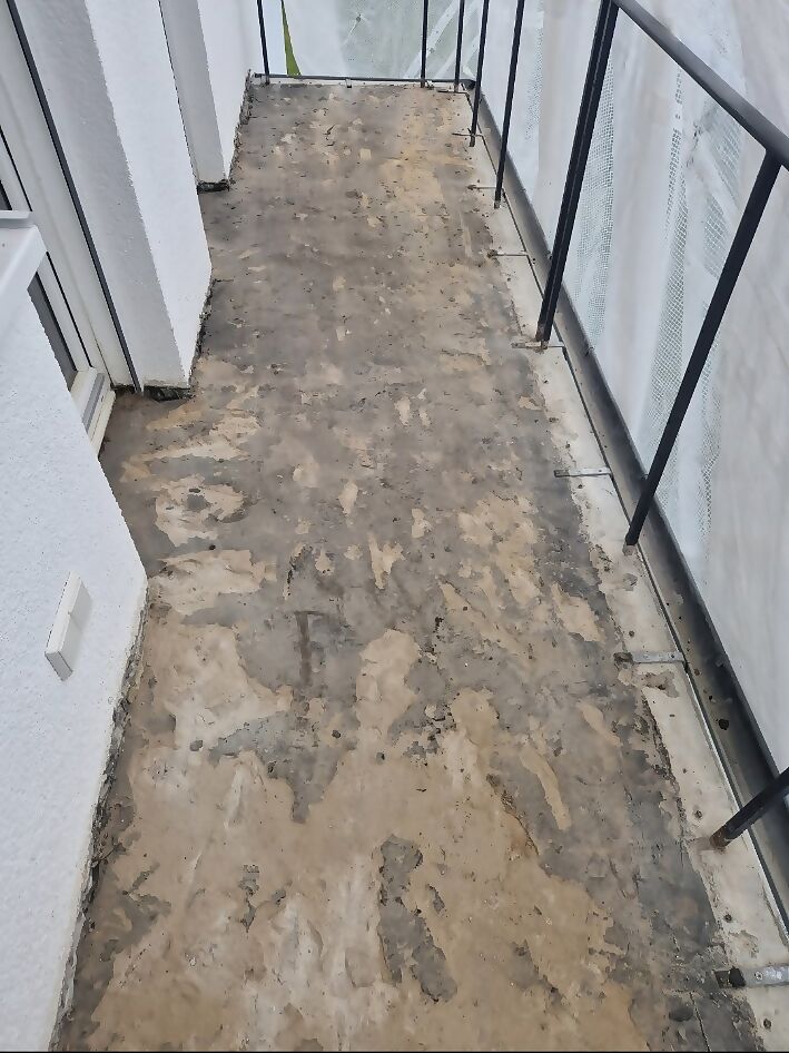 Dieselbe Terrasse vorher mit freigelegtem, fleckigem Untergrund